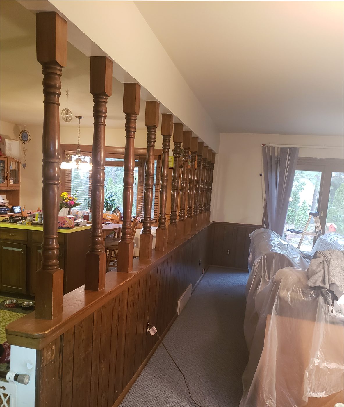 Before: Stained spindle half-wall painted gray, paneling painted white